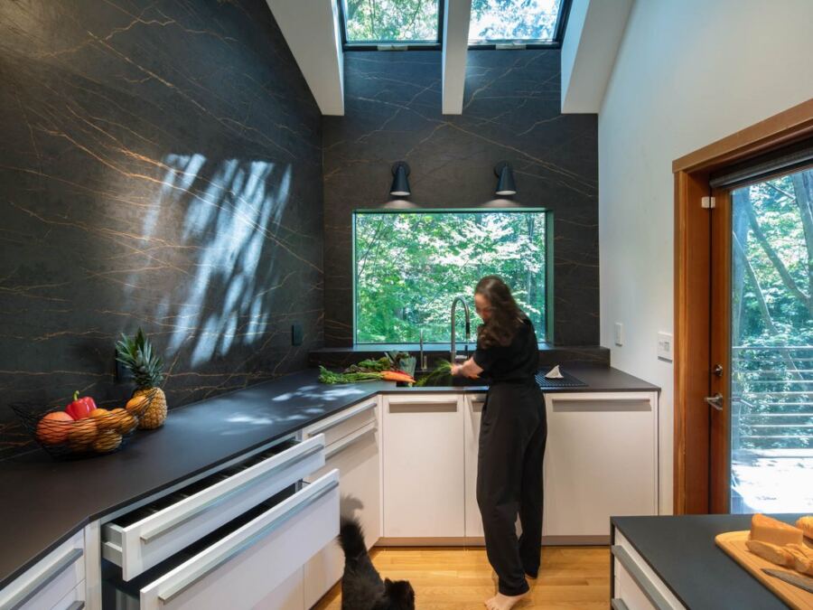 Full-height Inalco porcelain wall carried around a window return above the sink run, fabricated by Custom Touch Granite