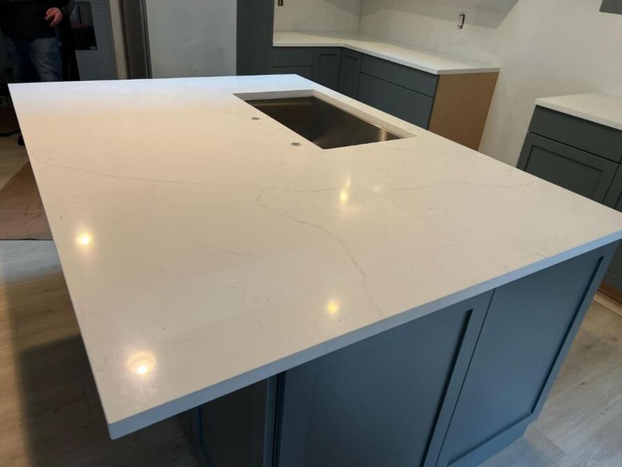 White quartz island top over blue cabinetry